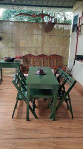 a green table and chairs in a room at Nature Stay - Private Water Stream and a Pool in Aldūr