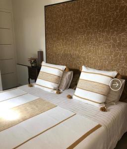 a bedroom with a large bed with two pillows at Villa Le Rubis in Agon Coutainville