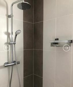 a shower with a shower head in a bathroom at Villa Le Rubis in Agon Coutainville