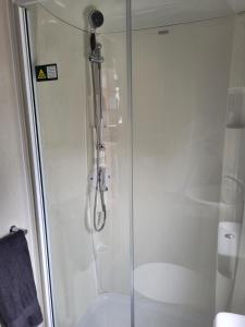 a shower with a glass door in a bathroom at Elegant 2 Bedroom En-Suite Caravan with Bathtub near Edinburgh Seton Sands Holiday Village in Port Seton +36 photos