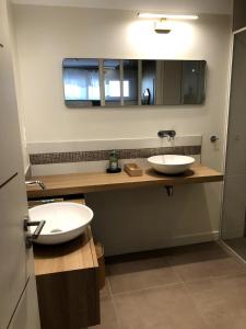 a bathroom with two sinks and a mirror at Villa Le Rubis in Agon Coutainville +16 photos
