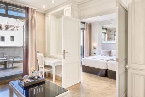 a bedroom with a bed and a desk in a room at VP Jardín de Recoletos in Madrid
