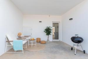a white room with a table and chairs and a camera at Villa Serena Blanca by Villalia Luxury Oasis & Private Pool in Playa Blanca +9 photos
