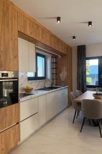 a kitchen with white cabinets and a table and a dining room at Villa VELUNA Liznjan Residence in Ližnjan