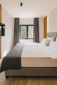 a bedroom with a large white bed with a window at Villa VELUNA Liznjan Residence in Ližnjan +48 photos