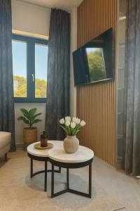 a living room with a table with a vase of flowers on it at Villa VELUNA Liznjan Residence in Ližnjan