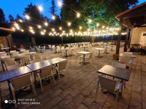 un patio esterno con tavoli, sedie e luci di Maison des Cévennes - Refuge ad Arphy