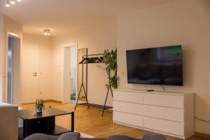 a living room with a television on a white dresser at Gemütlich wohnen im Herzen des Hunsrücks in Emmelshausen +5 photos
