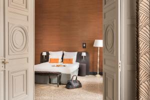 a hotel room with a bed and a door at Appart'City Collection Nîmes Arènes in Nîmes