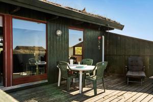 a patio with a table and chairs on a deck at TV1532-Skagen-Solbakken-55 in Skagen +14 photos
