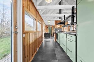 a kitchen with wooden walls and a large window at TV1658-Skagen-Klyngen-10 in Skagen