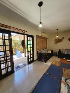 ein Wohnzimmer mit Sofa und Tisch in der Unterkunft Casa de condomínio 900m da Praia de Boiçucanga in São Sebastião