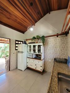 eine Küche mit einem weißen Kühlschrank und einer Spüle in der Unterkunft Casa de condomínio 900m da Praia de Boiçucanga in São Sebastião + 62 Fotos