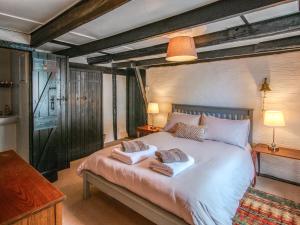 a bedroom with a large bed with two towels on it at Charlie Wilcox Cottage in Polperro