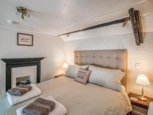 a bedroom with a bed with two towels on it at Charlie Wilcox Cottage in Polperro