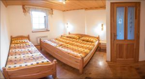 a bedroom with two beds and a window at Roubenka pod pralesem in Dolní Lomná