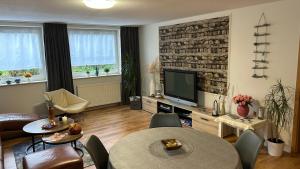 a living room with a table and a television at Fewo Stein in Altenbeken