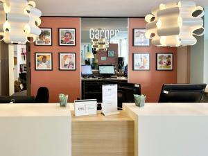 a reception desk in a dental office with a mirror at Garner Hotel Osnabrück by IHG in Osnabrück