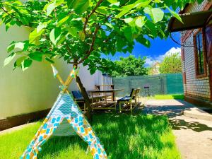 a tree in the yard with a table and chairs at Amore in Zatoka