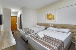 a hotel room with two beds with towels on them at Hotel Nacional Inn Piracicaba in Piracicaba