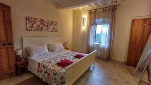 a bedroom with a bed with red roses on it at Il Sensalino in San Donato in Poggio