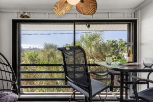 a dining room with a table and a view of the ocean at Unwind with Beach Bliss & Sunset Magic - Sunburst 113 in Punta Gorda Beach