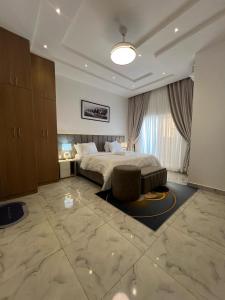 a bedroom with a bed and a chair in it at Xplora Real Estate in Gwarinpa