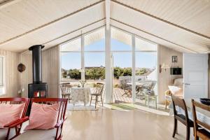 a living room with a fireplace and a table with chairs at LN1566-Hirtshals-Kloren-17 in Hirtshals
