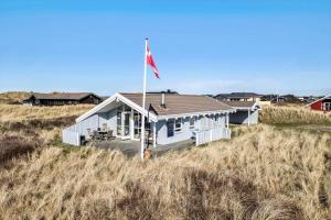 a house with a flag in the middle of a field at LN1566-Hirtshals-Kloren-17 in Hirtshals