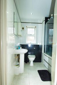 a white bathroom with a toilet and a sink at 3 Bed Semi - Sleeps 5 - Wifi - Private Garden & Parking - Pets Allowed in Grove Park