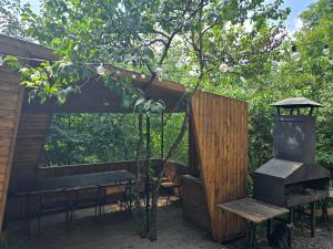 a wooden pergola with a bench and a table at Dilijanyan House in Dilijan