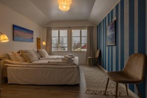 a bedroom with a bed and a window and a chair at Loimu Resort in Ylläsjärvi
