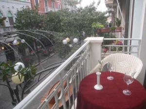 een balkon met een tafel met een rode tafelkleed en twee glazen bij Lina's Apartment in Grado