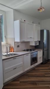 a kitchen with white cabinets and a stainless steel refrigerator at Al Campanile a stylish new apartment San Vito Romano Rome in San Vito Romano