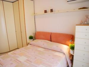 een kleine slaapkamer met een bed en een dressoir bij Lina's Apartment in Grado