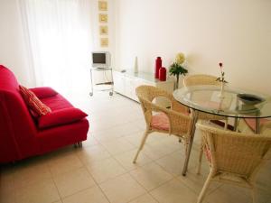 een woonkamer met een rode bank en een glazen tafel bij Lina's Apartment in Grado