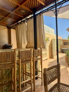 an outdoor table with chairs under an umbrella at Riad Miss Caracal in Marrakech