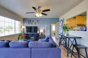 a living room with a blue couch and a ceiling fan at 4 Mi to Dtwn San Diego Cozy Getaway with Patio! in San Diego