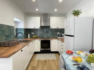 a kitchen with white cabinets and a white refrigerator at Peaceful Mountain Getaway - A Herança in Vila de Rei