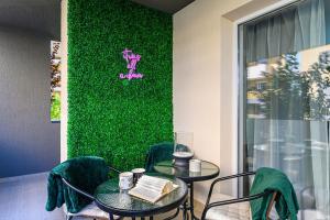 a room with two tables and a green wall at OCCO by the Mountains in Braşov