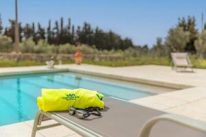 una borsa gialla seduta su un tavolo accanto alla piscina di Villa Incantesimo a Marina di Pescoluse