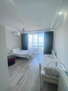 a large room with two beds and a large window at Guest House Geno in Kvariat'i