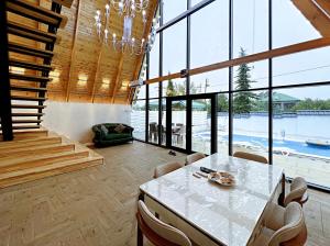 a dining room with a table and some windows at ES Dream A-Frame Cabin in Gabala