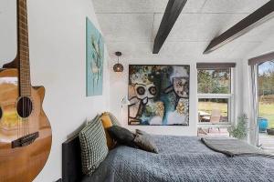 a bedroom with a bed and a guitar on the wall at BL1074-Saltum-Solmarken-3 in Saltum