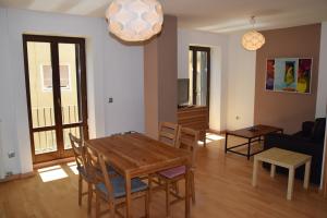 a dining room and living room with a table and chairs at Apartamentos Zaragoza Coso in Zaragoza +26 photos