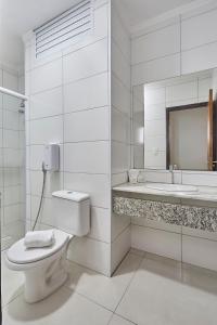 a white bathroom with a toilet and a sink at Hotel Nacional Inn Piracicaba in Piracicaba +20 photos