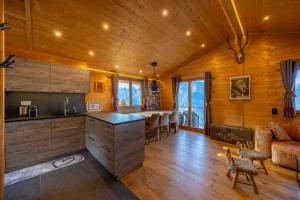 eine Küche mit einer Bar und einem Sofa in einem Zimmer in der Unterkunft Chalet Chanterelle - Cosy et montagnard in Plan Fey