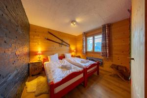 ein Schlafzimmer mit einem Bett in einer Holzwand in der Unterkunft Chalet Chanterelle - Cosy et montagnard in Plan Fey