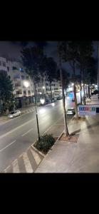 two trees on a city street at night at bel et comfortable appartement centre agdal in Rabat