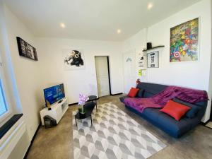 a living room with a blue couch and a tv at L'escale Urbaine avec fibre internet 4 pers Confort & Emplacement Idéal in Marmande